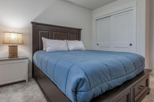 a bedroom with a bed with a blue blanket at Hideaway in Seaside in Seaside