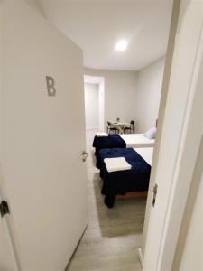 Cette chambre comprend deux lits et un couloir. dans l'établissement Funchal Apartments - New Botanic Garden Petit Studios, à Funchal