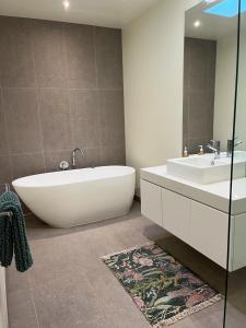 a bathroom with a tub and a sink at Serendipity Vista in Warrnambool