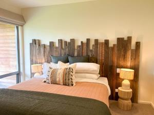 a bedroom with a large bed with a wooden headboard at Serendipity Vista in Warrnambool