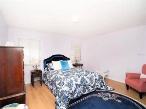 sypialnia z łóżkiem z niebiesko-białą narzutą w obiekcie Charming Vintage Haven w mieście Tarpon Springs