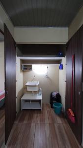 a bathroom with a white sink and a wooden floor at Casa completa com 2 quartos de casal em Torres in Torres