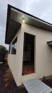 ein weißes Haus mit einem schwarzen Dach und einem Fenster in der Unterkunft Casa completa com 2 quartos de casal em Torres in Torres