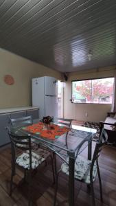 kuchnia ze szklanym stołem i 2 krzesłami w obiekcie Casa completa com 2 quartos de casal em Torres w mieście Torres