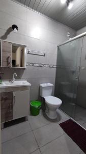 a bathroom with a shower and a toilet and a sink at Casa completa com 2 quartos de casal em Torres in Torres