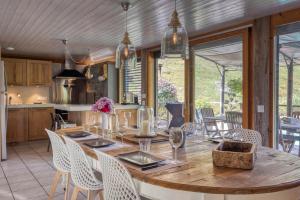 a kitchen and dining room with a wooden table and chairs at Le Chalet des Eaux - Thermes - Ski in Revel
