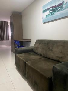 a living room with a brown couch and a table at Flat com ótima localização - 505 in Campina Grande