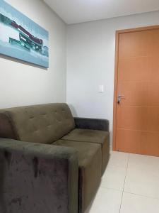 a living room with a couch and a wooden door at Flat com ótima localização - 505 in Campina Grande