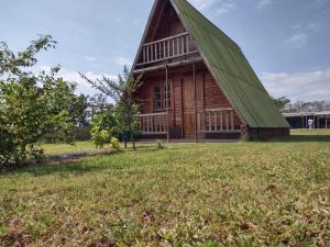 a large wooden barn with a green roof on a field at Casa de Campo / Sítio + Chalé Suíço + Área Festa + Piscina in Tatuí