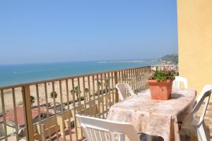 a table and chairs on a balcony with the ocean at Terrazza sul Mare Vecchio Pontile in Gela