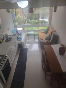 a kitchen and living room with a couch and a table at Lindo Loft na Praia de Barra do Una à beira do Rio in São Sebastião