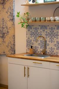 uma cozinha com um lavatório e um papel de parede azul e branco em Al Alma Apart-Suites em Cartagena das Índias