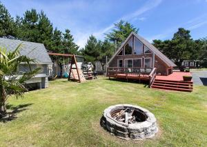 a yard with a house and a tire in the grass at Silver Star in Rockaway Beach