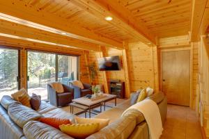 una sala de estar con sofá y TV en una cabaña de madera en Westwood Lakefront Cabin with Hot Tub and Boat Dock! en Westwood