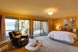 1 dormitorio con 1 cama, 1 silla y 1 ventana en Westwood Lakefront Cabin with Hot Tub and Boat Dock! en Westwood