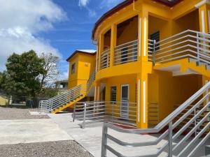 a yellow building with stairs on the side at Poinciana Villas in Woods