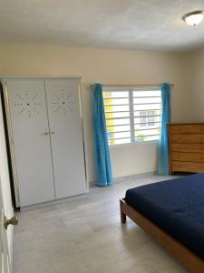 ein Schlafzimmer mit einem Bett, einem Schrank und einem Fenster in der Unterkunft Poinciana Villas in Woods