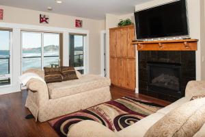 sala de estar con 2 sofás y chimenea en Michael's Beach Place @ Shoreline Ridge en Newport