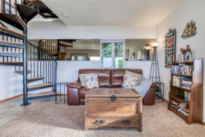 uma sala de estar com um sofá de couro castanho e uma escadaria em The Lookout em Newport