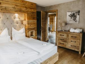 - une chambre avec un grand lit blanc et une commode dans l'établissement Chalet-Apartment Alpenrose am Lift, à Kirchberg in Tirol