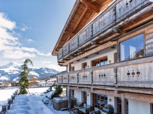 un edificio con balcón en la nieve en Chalet-Apartment Alpenrose am Lift en Kirchberg in Tirol