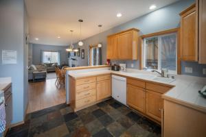 a kitchen with wooden cabinets and a living room at Necanicum House in Seaside