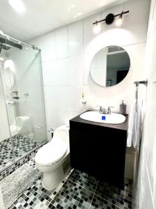 a bathroom with a sink and a toilet and a mirror at Vive como un local en Popayan in Popayan