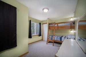 a bedroom with bunk beds and a flat screen tv at Necanicum House in Seaside