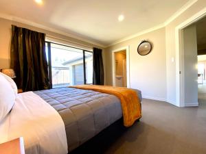 a bedroom with a bed with an orange blanket on it at Rhoboro Retreat in Twizel