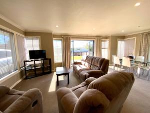 a large living room with couches and a television at Rhoboro Retreat in Twizel