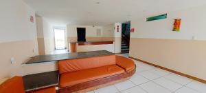 una habitación con un sofá naranja en una habitación en COPFL0100 - Condomínio Recanto do Flamengo en Salvador