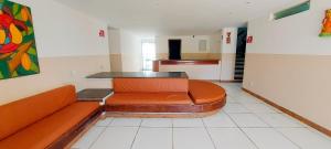 een wachtkamer met een oranje bank in een gebouw bij COPFL0100 - Condomínio Recanto do Flamengo in Salvador
