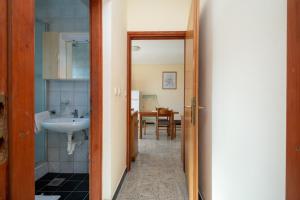 korytarzem do łazienki z umywalką i stołem w obiekcie Apartments by the sea Razanac, Zadar - 5766 w Ražancu