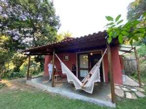 a house with two hammocks in front of it at Vila Verde Perto in Lençóis