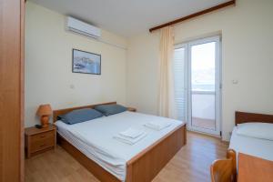 sypialnia z łóżkiem i dużym oknem w obiekcie Apartments by the sea Razanac, Zadar - 5766 w Ražancu