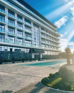 a large building with a swimming pool in front of it at Lighthouse, Sea Breeze in Baku