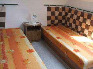 um quarto com 2 camas e uma mesa com um candeeiro em Feherszeker apartmanok em Abádszalók