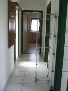 um corredor com piso em azulejo e um andarilho em Feherszeker apartmanok em Abádszalók