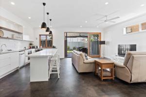 a kitchen and living room with a couch and a table at Perfect Palm Beach Townhouse - Hosted by Burleigh Letting in Gold Coast