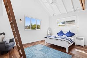 a white room with a bed and a chair at Perfect Palm Beach Townhouse - Hosted by Burleigh Letting in Gold Coast