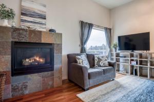 a living room with a fireplace and a chair at Sea Depoe Bay in Depoe Bay