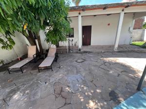 a group of benches sitting in front of a building at Flores Condominios Depa Rosa in Álamos