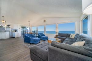 a living room with a couch and chairs and the ocean at Lawton's View in Lincoln City