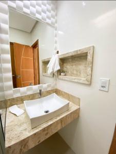 uma casa de banho com um lavatório e um espelho em Apartamentos Villa dos Diamantes em Porto Seguro