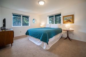 a bedroom with a large bed and two windows at Lawton's View in Lincoln City