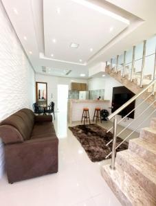 a living room with a couch and a staircase at Apartamentos Villa dos Diamantes in Porto Seguro