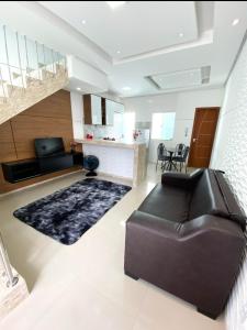a living room with a leather couch and a rug at Apartamentos Villa dos Diamantes in Porto Seguro