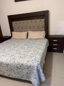 a bedroom with a large bed with a large headboard at Flores Condominios Depa Rosa in Álamos