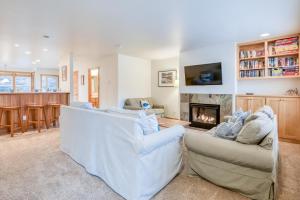 a living room with two white couches and a fireplace at Beach Break in Pacific City