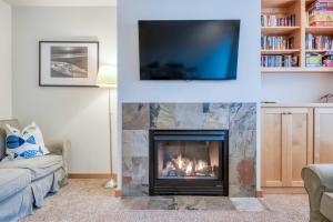 a living room with a fireplace and a flat screen tv at Beach Break in Pacific City